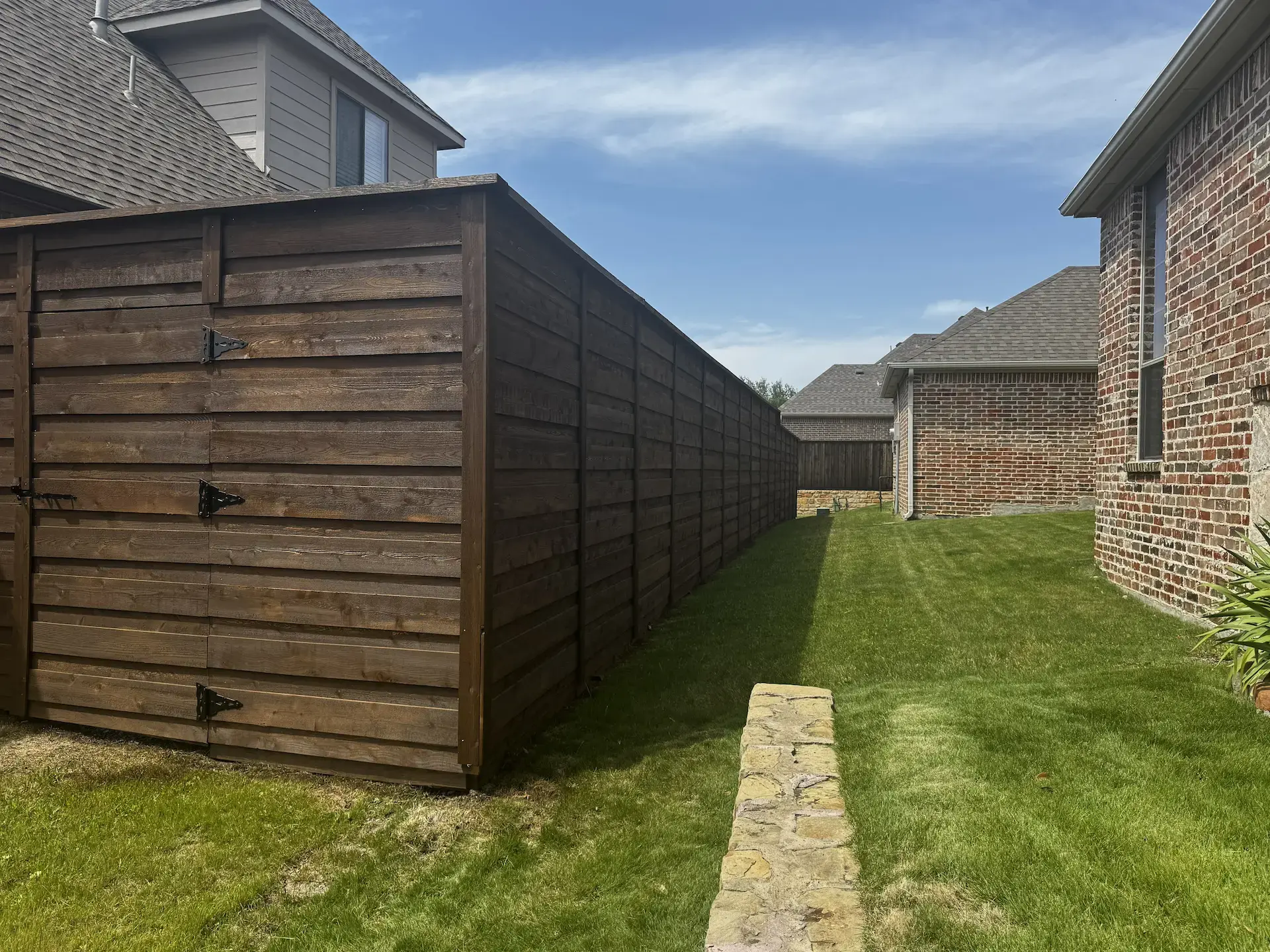 Brown stained wooden fence in a residential alleyway